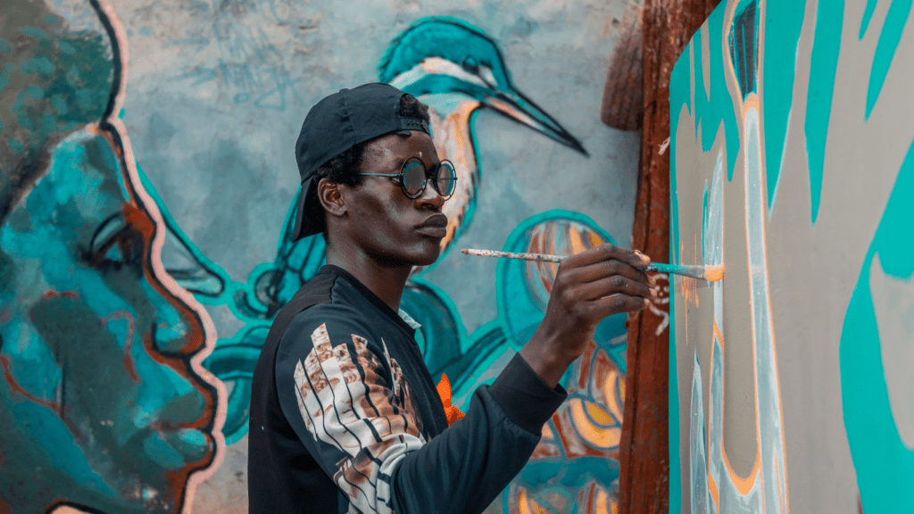 a man doing an artwork in a wall