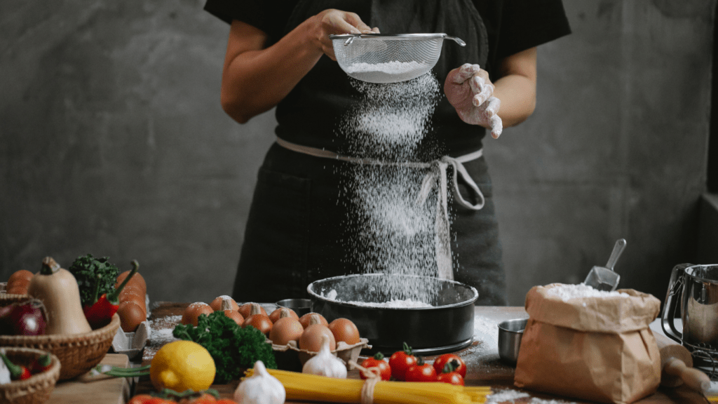 person sifting a baking cuisine